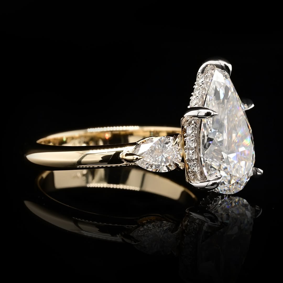 High-detail side angle highlighting the brilliant facets of the 4 CT pear-cut center lab diamond and smooth yellow gold shank