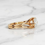 Low-profile side view showing the fluid split band architecture of an East-West pear diamond bezel ring.