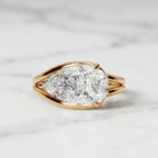 Direct top view displaying the brilliant horizontal pear cut diamond set in a gold bezel setting.