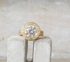 Front view of a 4 CT round lab grown diamond ring with brushed yellow gold halo bezel and flush diamond accents.