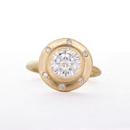 Direct top view of a 4 CT round lab grown diamond set in a wide satin-brushed gold halo with six flush diamond accents.