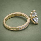 Side view showing the basket setting and double pavé band architecture of a gold princess cut ring.