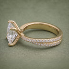 Detailed profile view of the double-row pavé band running up the shank of a yellow gold engagement ring.
