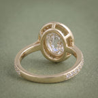 Inside shank and open lattice undergallery view of a yellow gold oval bezel halo diamond ring.
