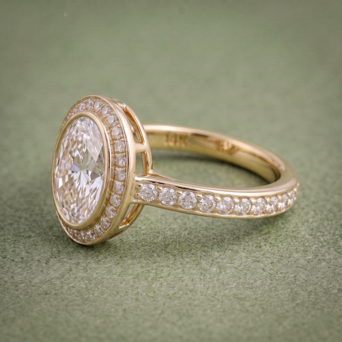 Side profile of a gold bezel halo ring showing the raised gallery construction and diamond pavé band.