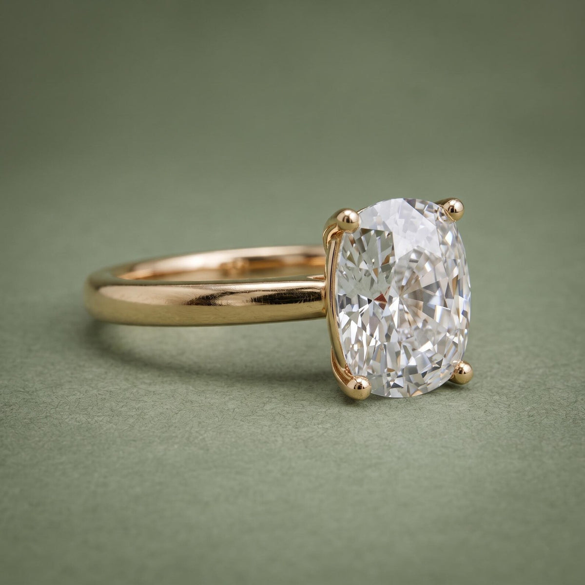 Angled front perspective of a 3 CT elongated cushion cut lab grown diamond solitaire ring in 18K yellow gold.