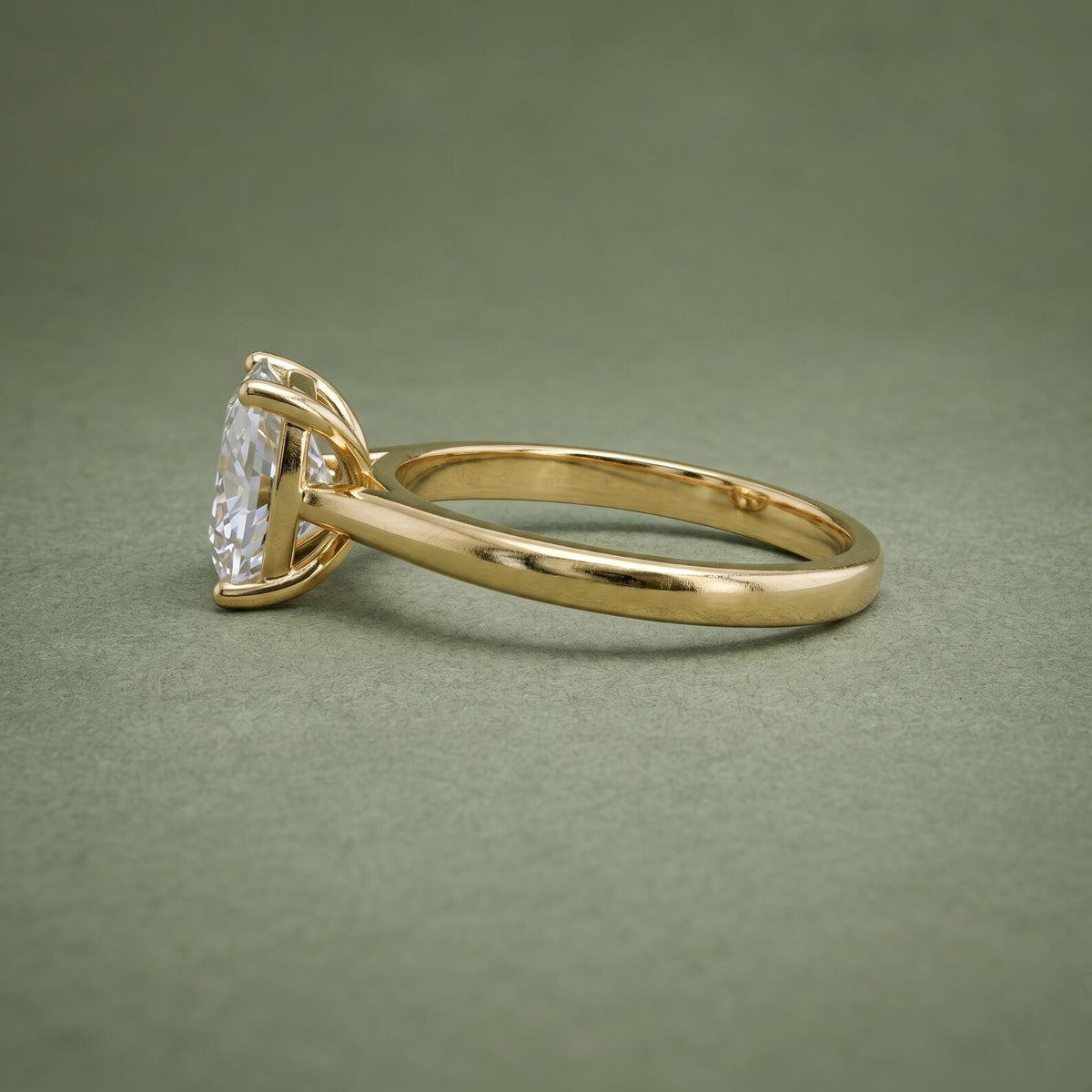 Side view displaying the open basket gallery and polished yellow gold shank of a cushion cut diamond ring.