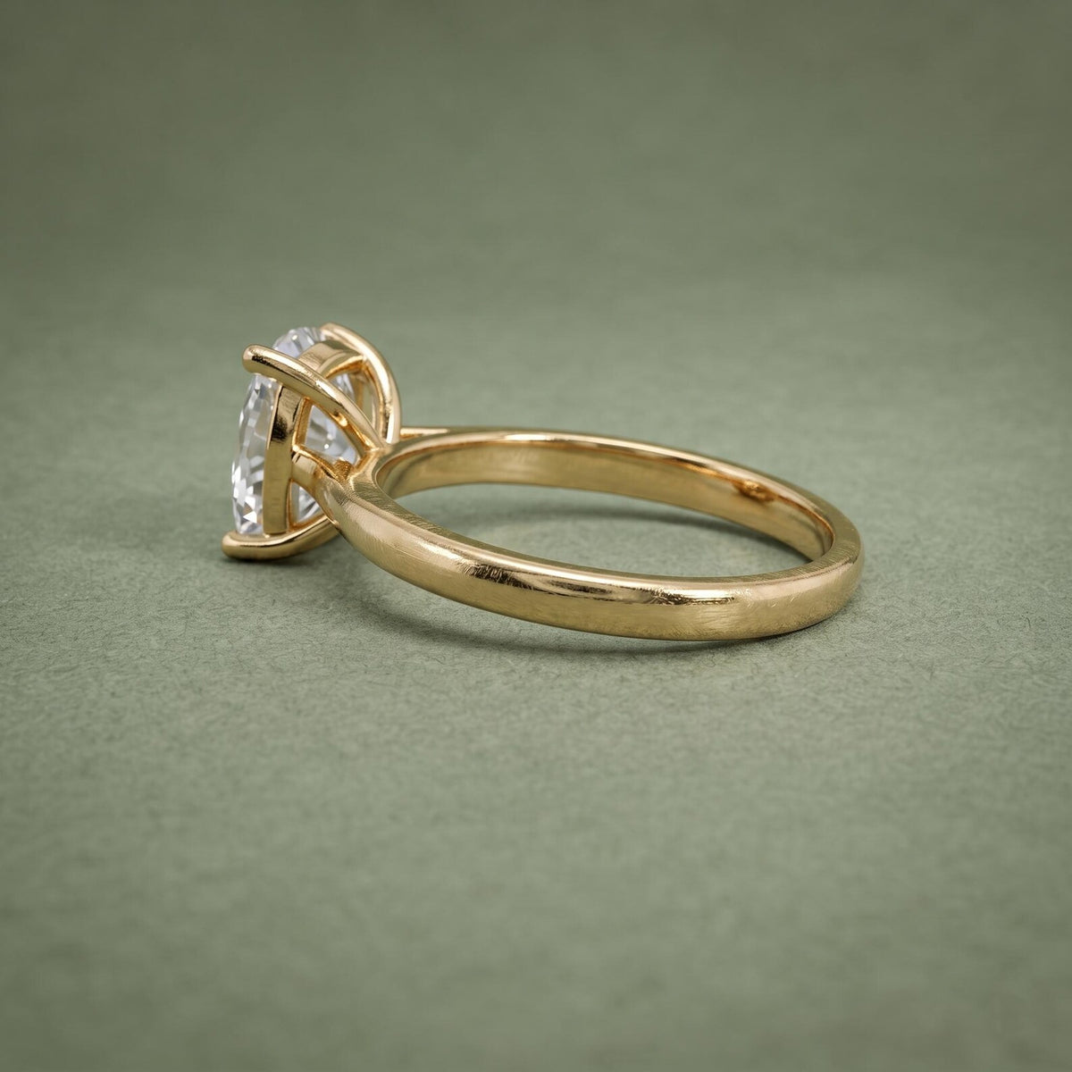 Close profile view of the raised 4-prong setting cradling a 3 carat cushion cut lab grown diamond.