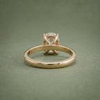 Underside view of a yellow gold diamond solitaire ring showing the inner band curve and open gallery base.