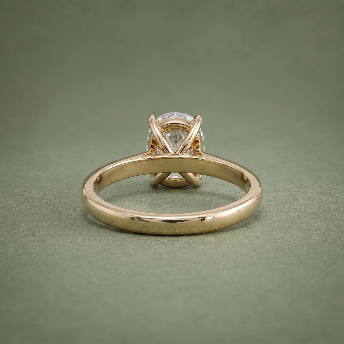 Underside view of a yellow gold diamond solitaire ring showing the inner band curve and open gallery base.