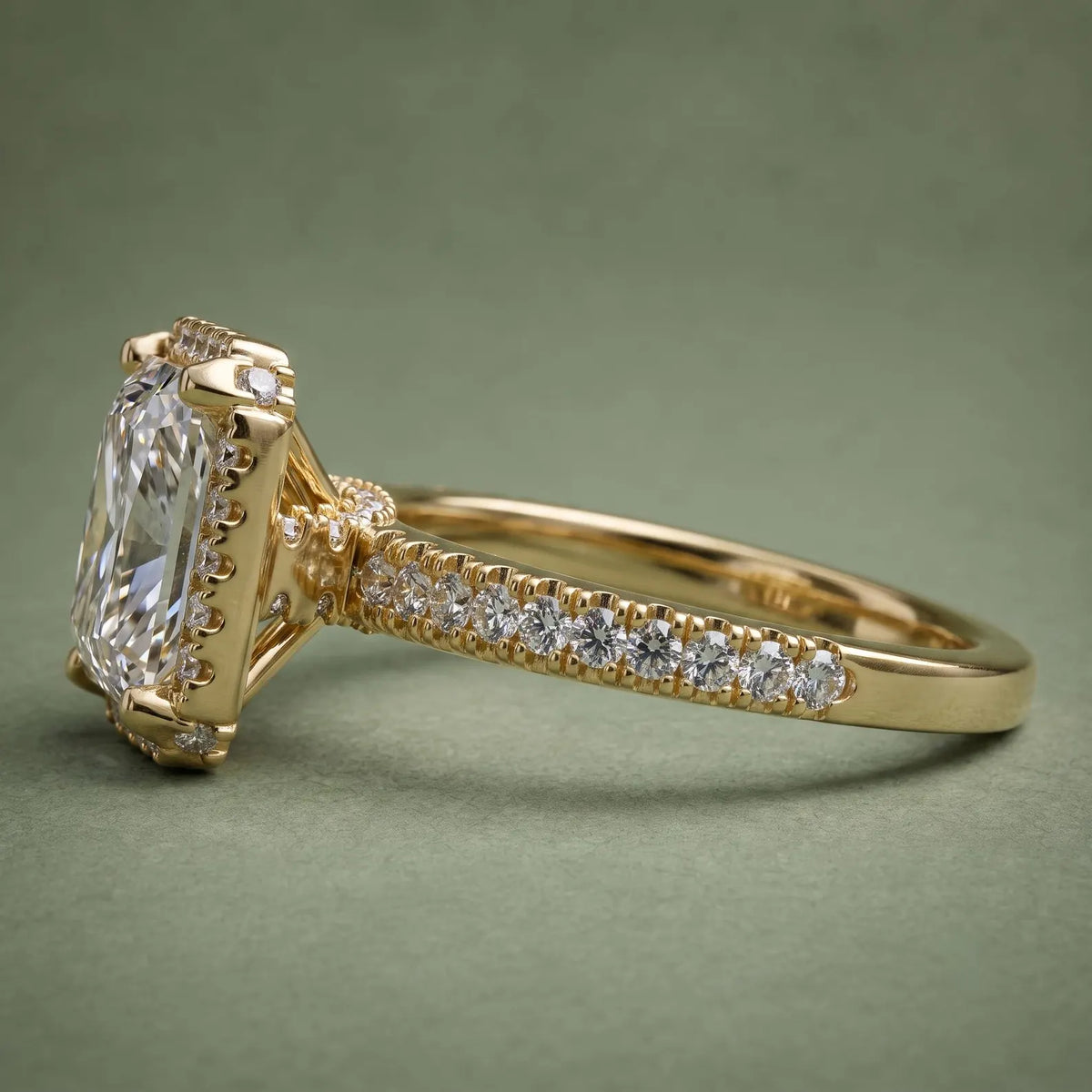 Side profile view of a 4 CT princess cut lab grown diamond halo engagement ring in 18K yellow gold with pavé band.
