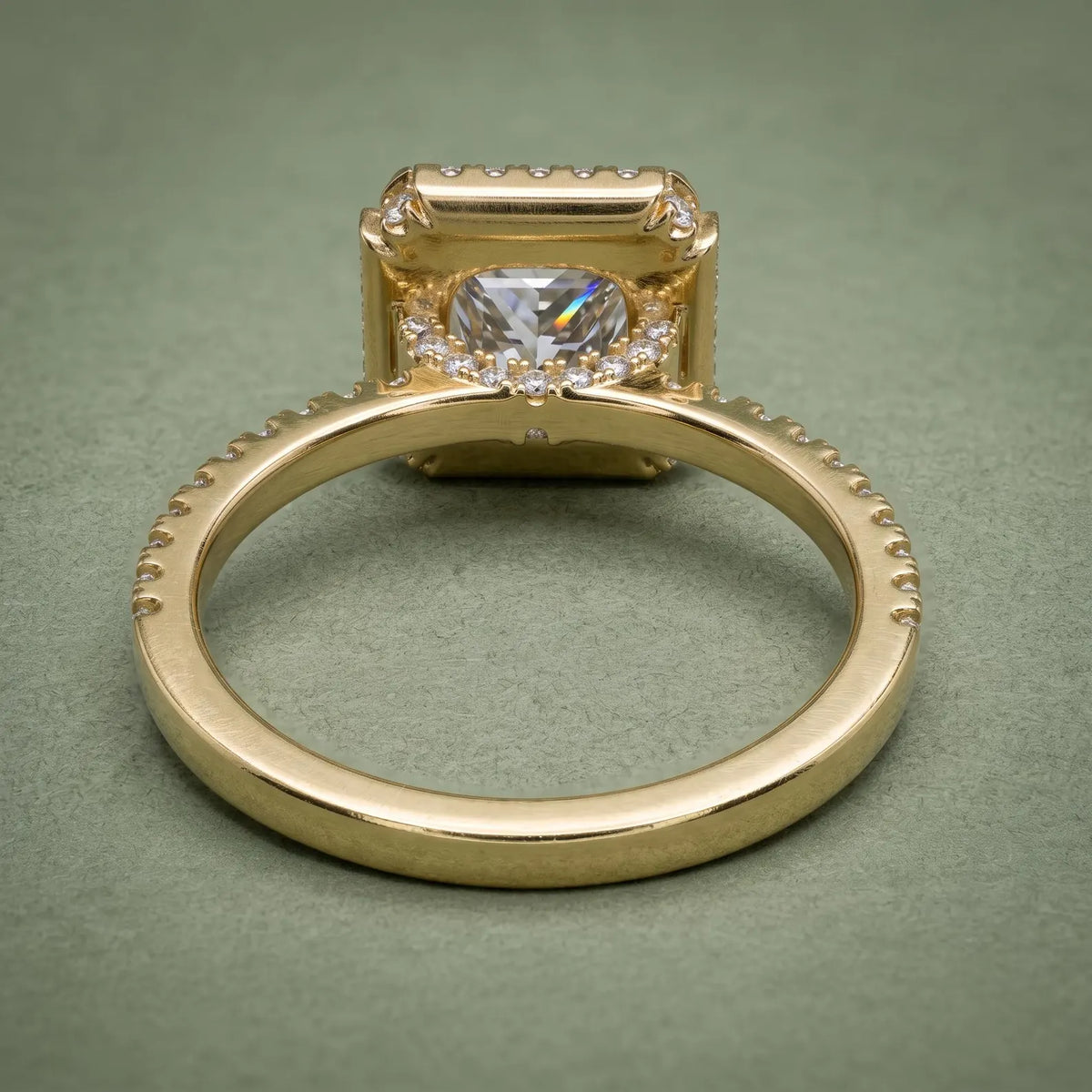 Underside view of a yellow gold engagement ring highlighting the halo gallery setting and inner ring band.