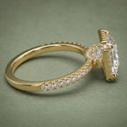 Angled side profile detailing the raised halo basket gallery and diamond accent bridge in yellow gold.