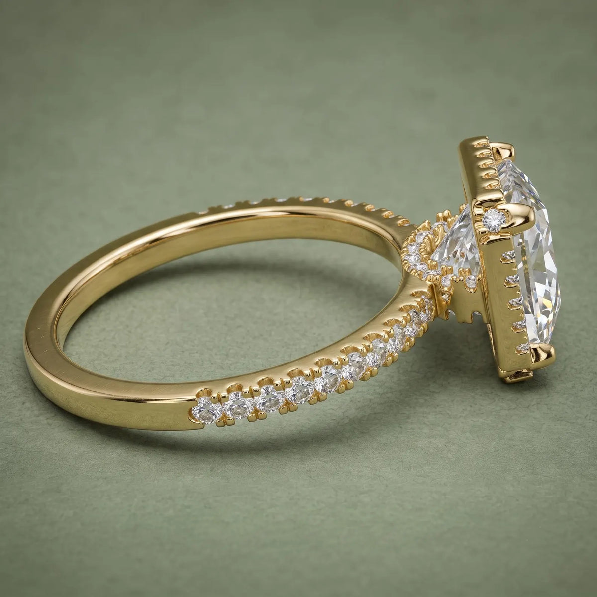 Angled side profile detailing the raised halo basket gallery and diamond accent bridge in yellow gold.