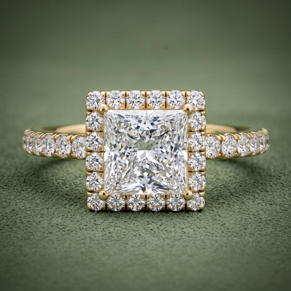 Top-down view of a 2 CT princess cut lab grown diamond halo ring with pavé shank in 14K yellow gold.