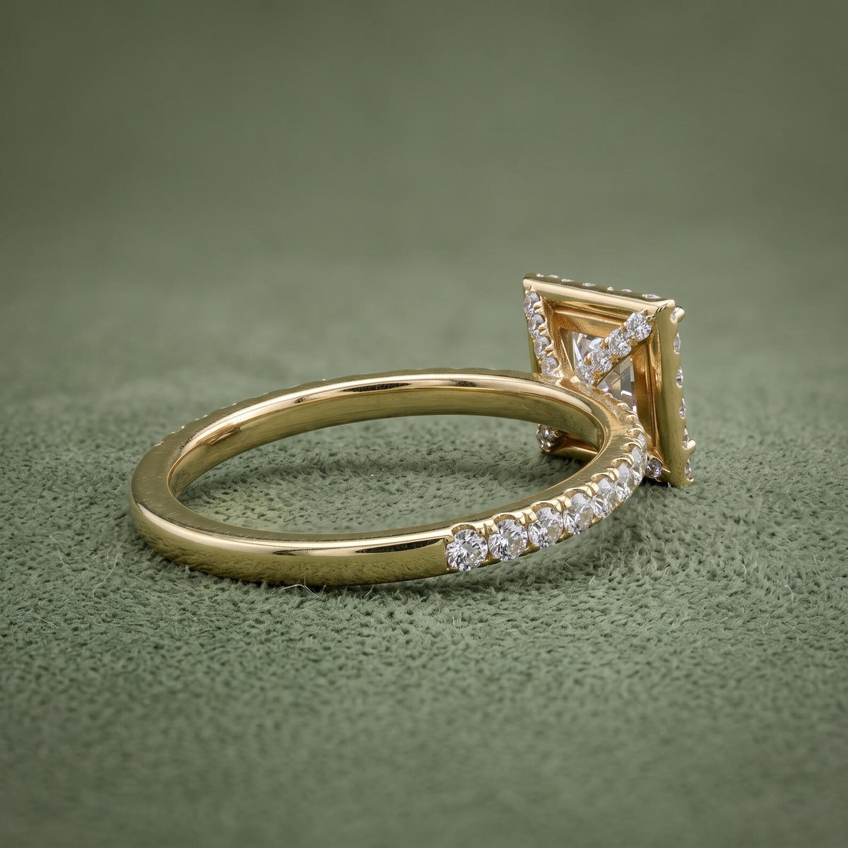 Side profile angle showing the diamond-accented undergallery bridge and pavé band on a yellow gold ring.