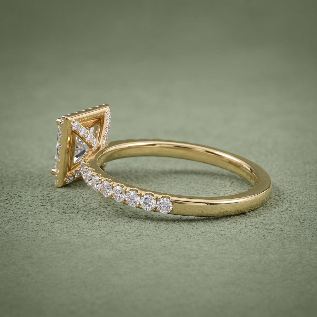 Close-up side view highlighting the micro-pavé diamond bridge work beneath the yellow gold halo setting.