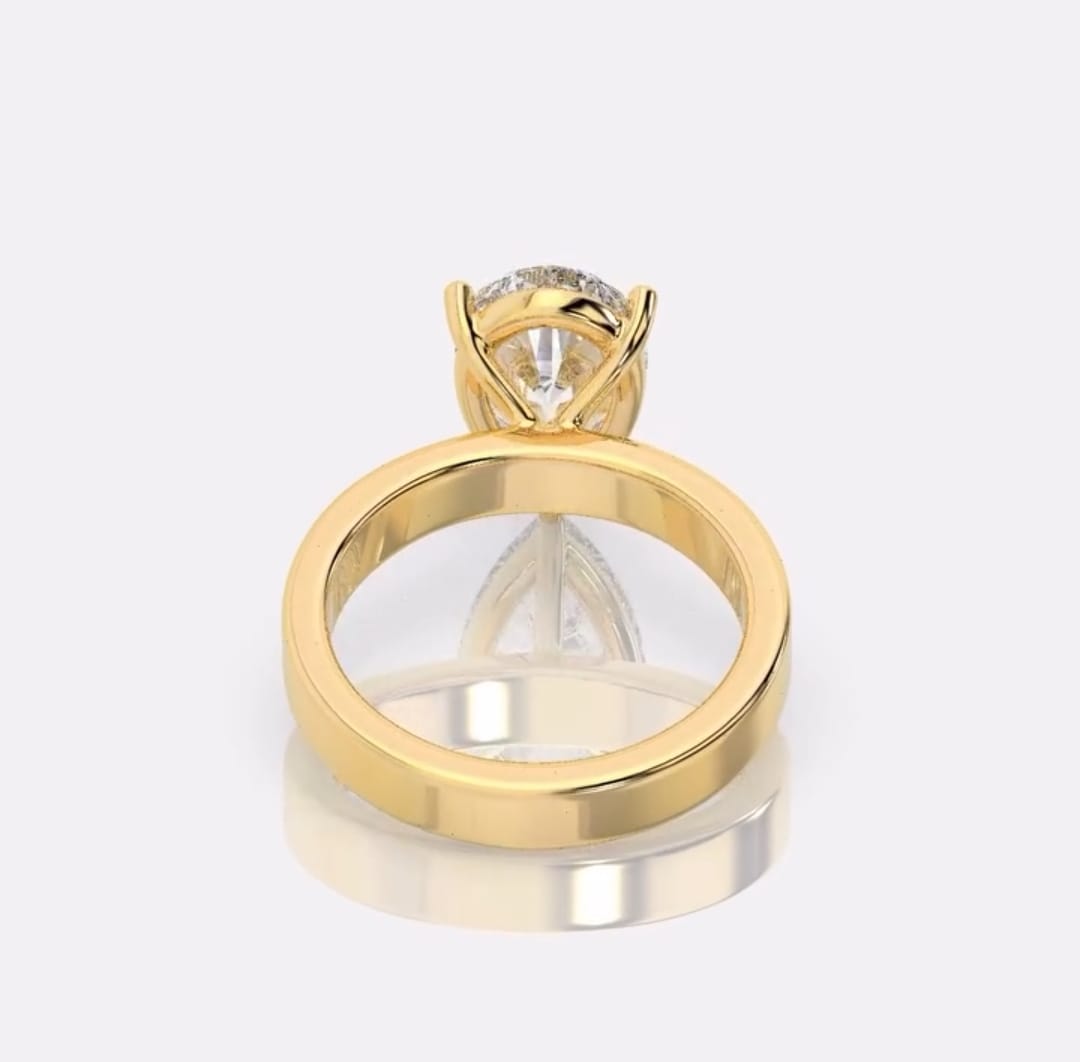 Bottom angle profile view highlighting the supportive yellow gold under-gallery and hidden halo setting holding the pear diamond.