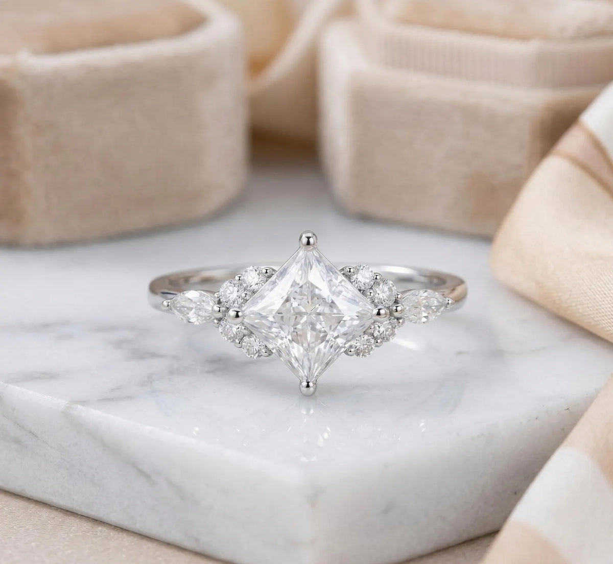 Front view of a 3 carat kite-set princess cut lab diamond engagement ring in white gold on marble.