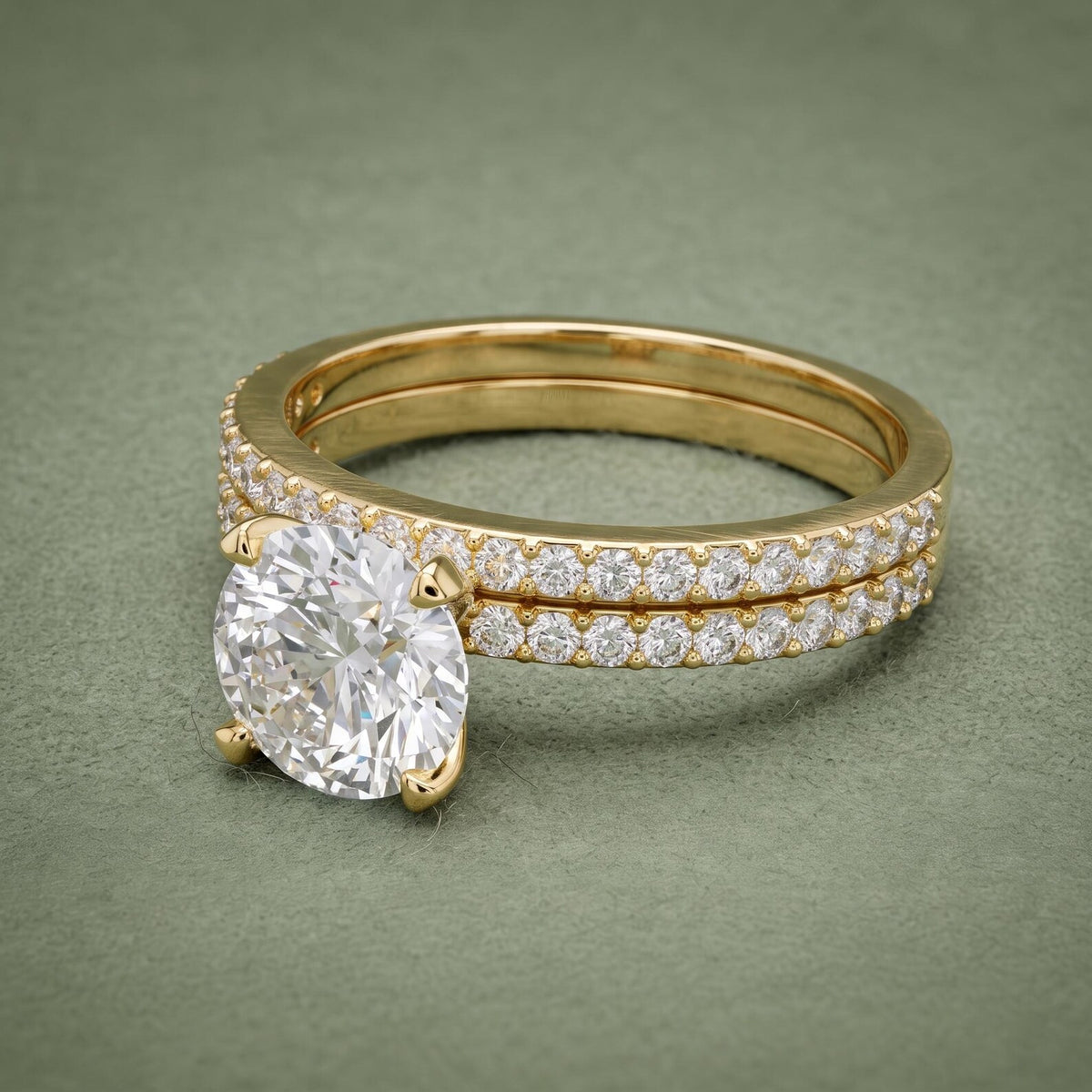Top angle view of a 3 carat round lab grown diamond solitaire and pavé wedding band set in yellow gold.
