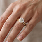 Model wearing 3 CT round cut lab grown diamond solitaire engagement ring and pavé wedding band on finger.