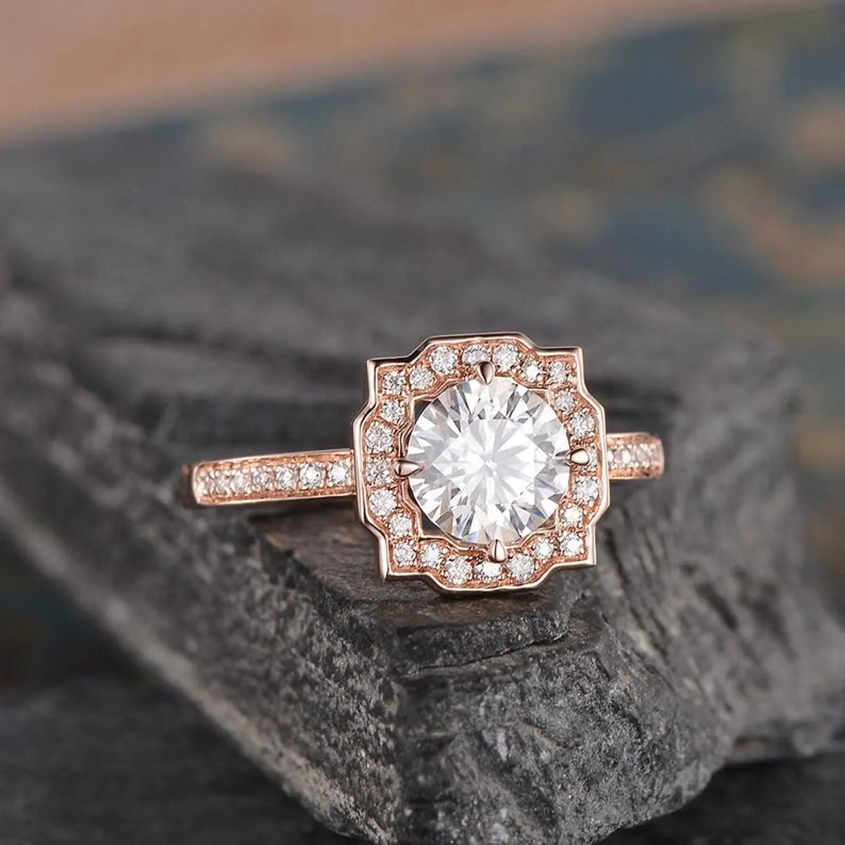 Angled view of a 2 carat round lab diamond vintage-inspired halo ring with pavé diamond band in rose gold.
