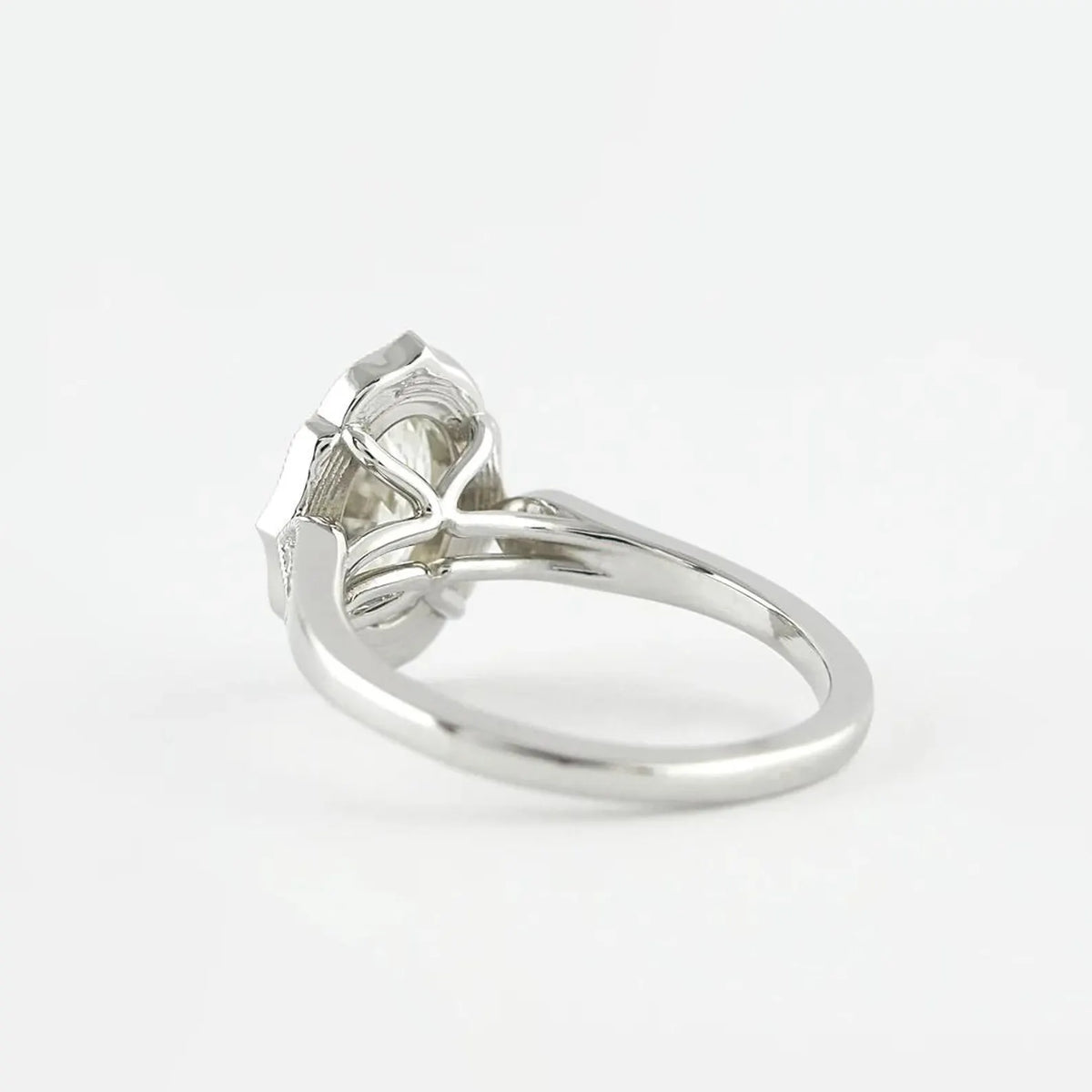 Rear angled view of a 3 CT oval lab grown diamond ring showing white gold arch basket structure.