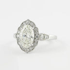 High-angle view of a 3 carat oval lab grown diamond engagement ring with a scalloped milgrain halo.