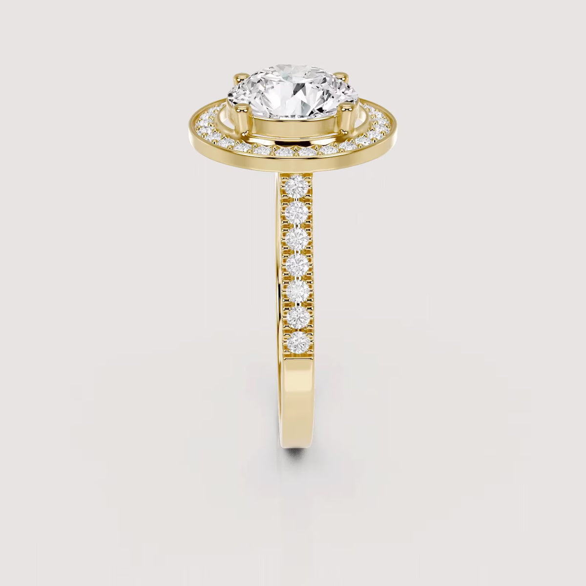Side profile view of a 4 CT round lab grown diamond halo ring with pave band in yellow gold.