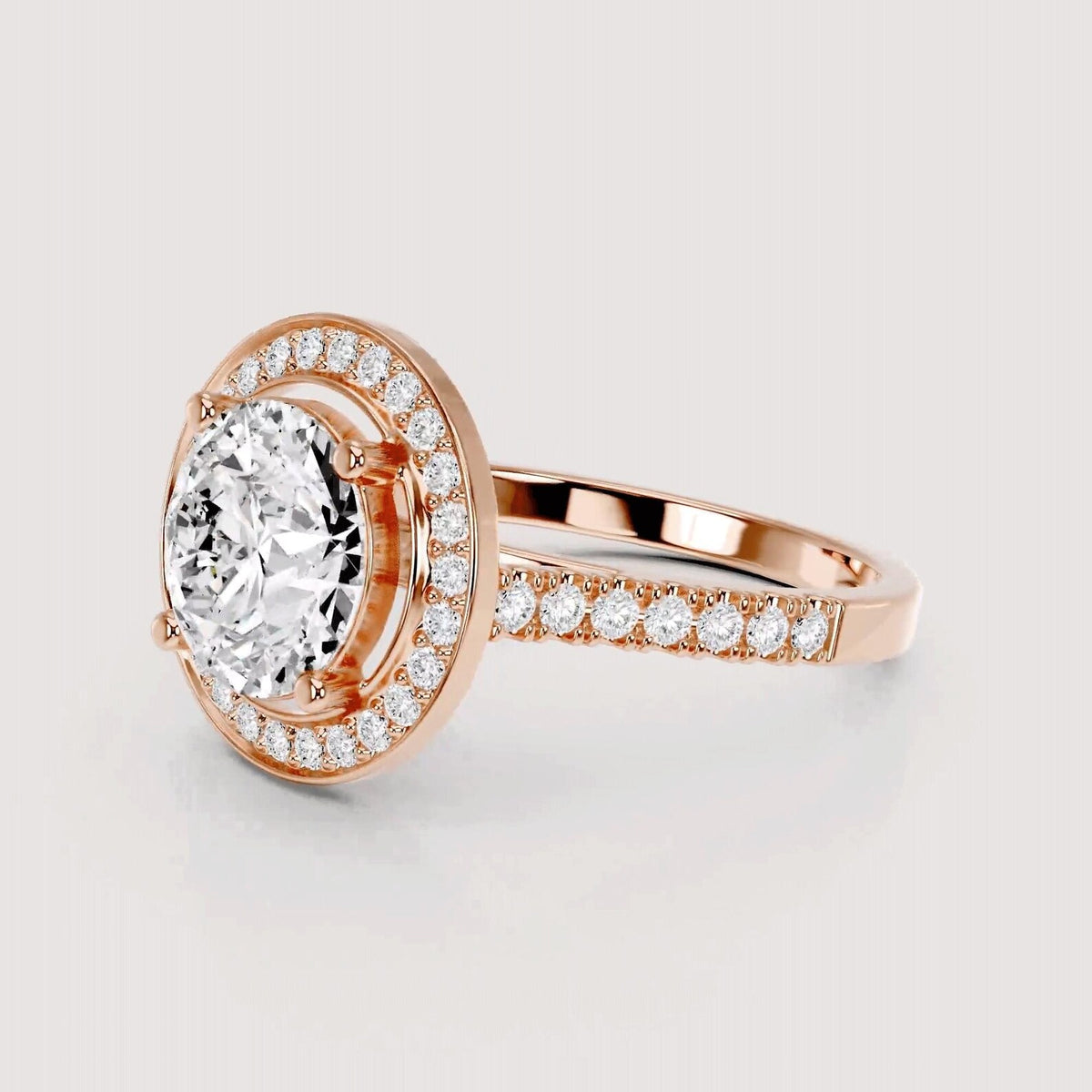 Rose gold halo engagement ring with a large round-cut center stone and pavé-set accent stones along the halo and band, shown on a light gray background.