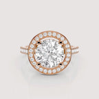 A rose gold halo ring featuring a large round-cut center stone surrounded by a double halo of smaller round stones, with a split shank band also accented with small stones, shown on a light gray background.