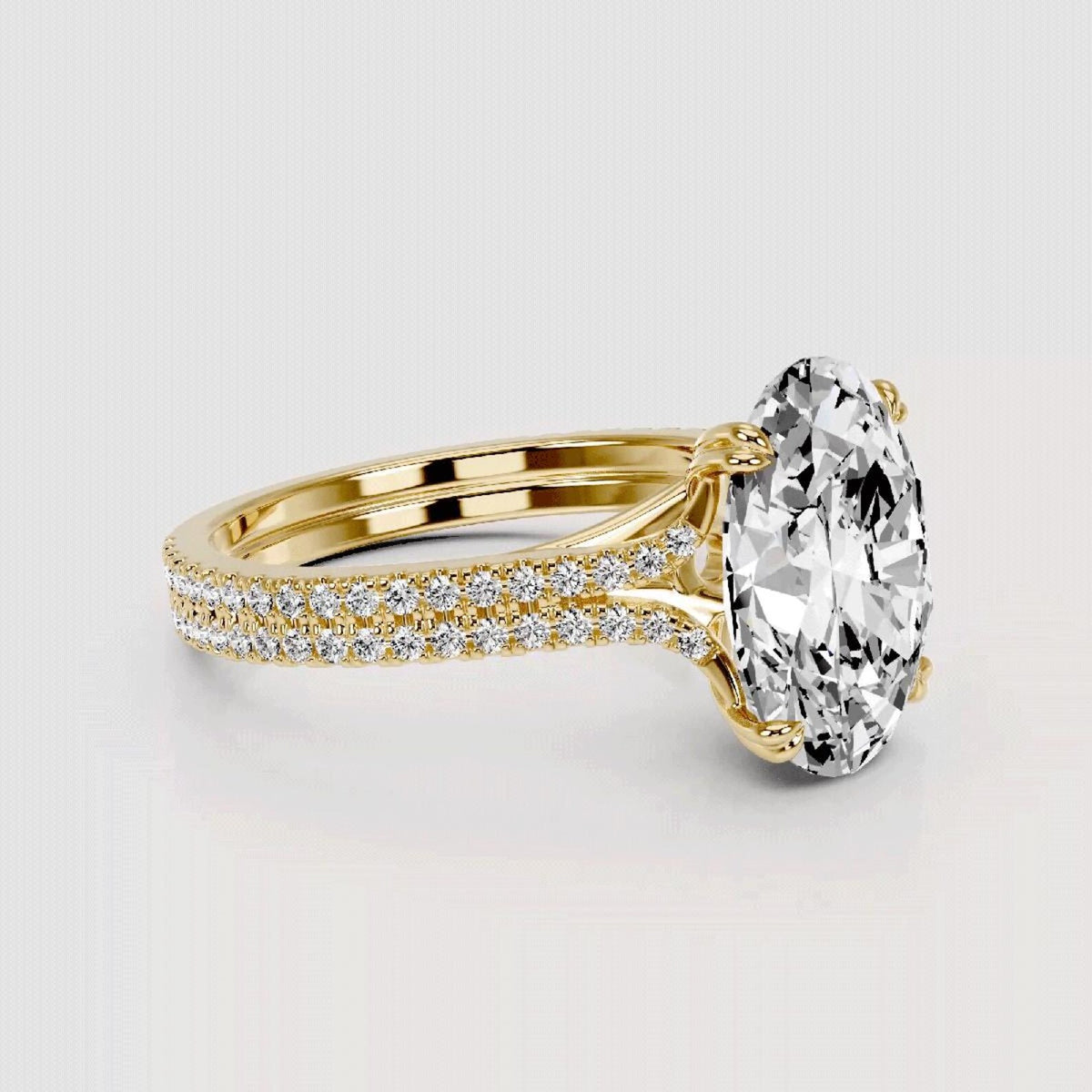 Gold ring with a large diamond and smaller diamonds on the band against a light gray background