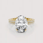 An oval-cut diamond engagement ring with a yellow gold band accented by pavé diamonds, shown on a light gray background.