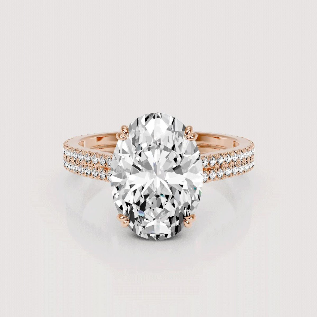 An oval-cut diamond engagement ring in a rose gold setting with a pavé band, shown on a light gray reflective background.