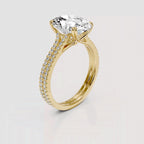 A yellow gold engagement ring featuring a large cushion-cut clear center stone and a pavé-set diamond band, shown on a light gray background.
