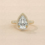 Top view showing 4 Carat Pear Cut Lab Grown Diamond Ring with halo setting and pave band in yellow gold