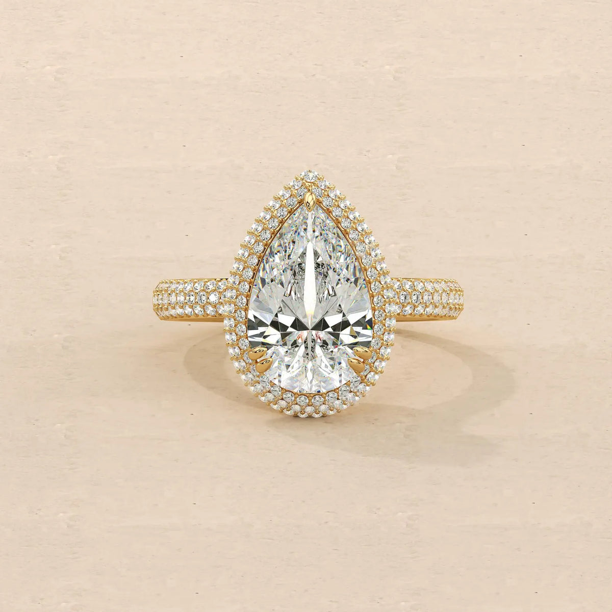 Top view showing 4 Carat Pear Cut Lab Grown Diamond Ring with halo setting and pave band in yellow gold