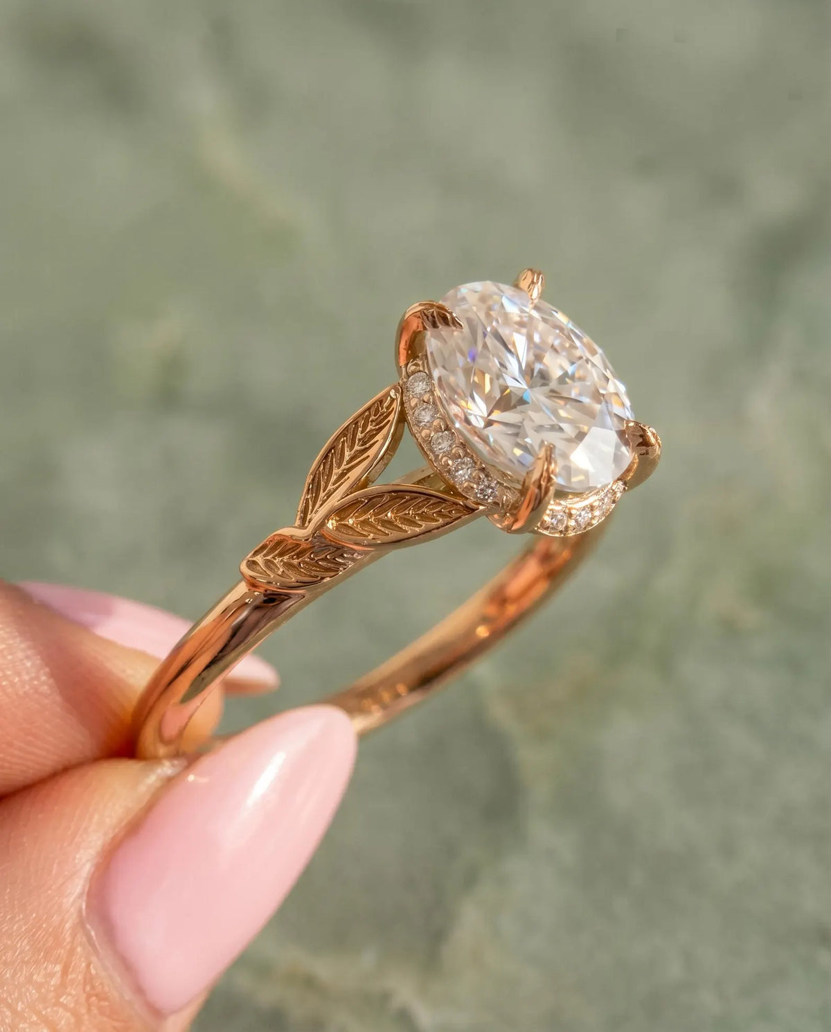 Side profile view displaying hidden halo and sculpted leaf shoulders on 2 Carat Oval Cut Lab Diamond Ring held in hand