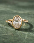 Top-down view of 3 Carat Oval Cut Lab Grown Diamond Engagement Ring with full bezel setting and flush-set accent diamonds on bypass band