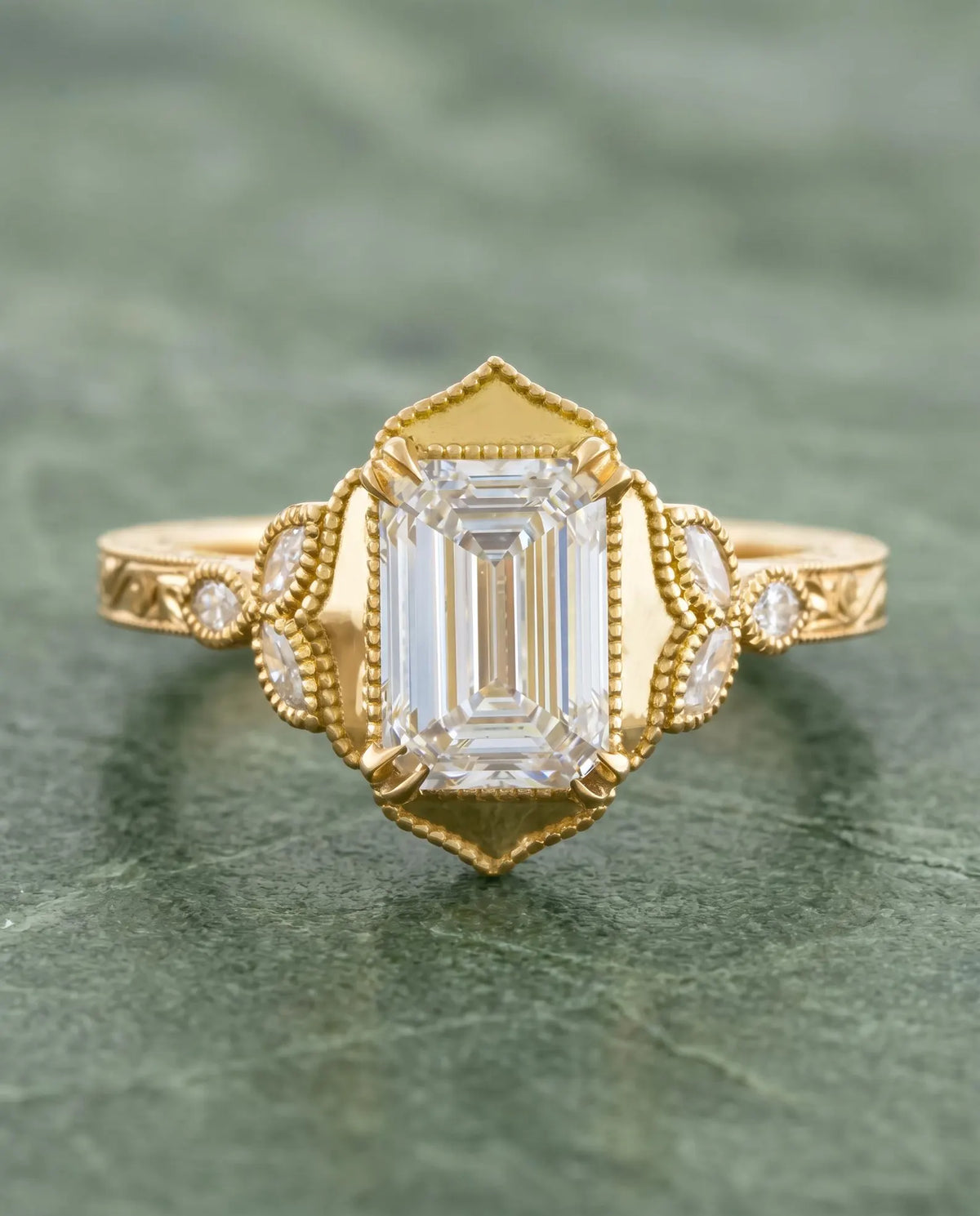 Top-down view of 3 Carat Emerald Cut Lab Grown Diamond Vintage Engagement Ring with pointed milgrain halo frame and engraved yellow gold band