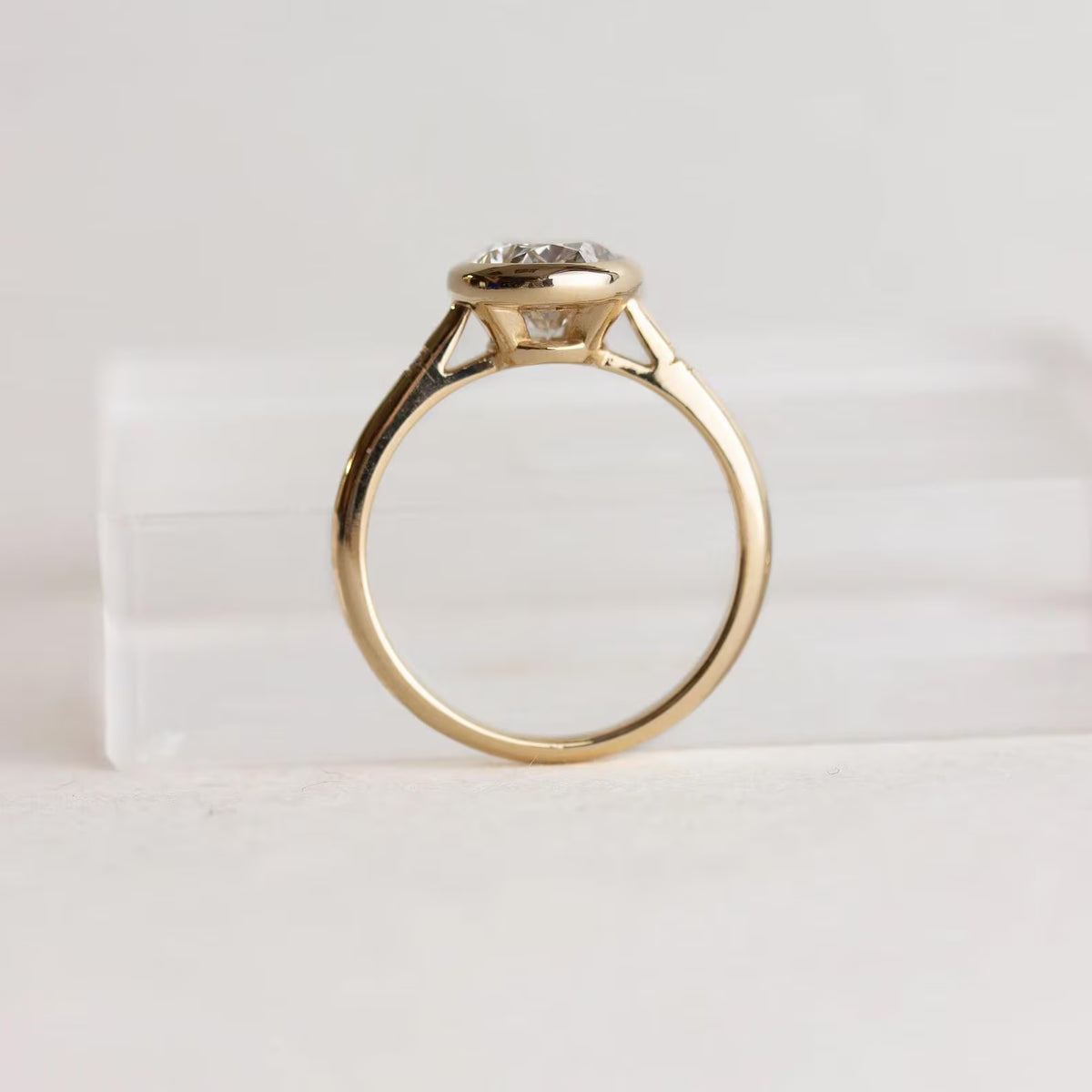 High-angle perspective view of 2 Carat Oval Cut Lab Grown Diamond Ring with smooth bezel setting and star-etched shoulder