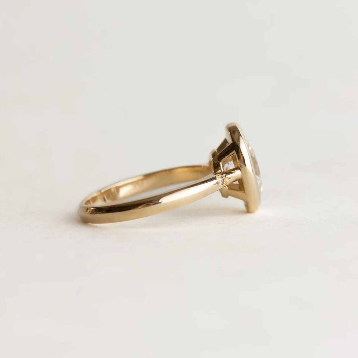 Close-up side view of 2 Carat Oval Lab Diamond Ring showing starburst-set diamond detail on the yellow gold band