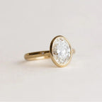 Direct side profile view of 2 Carat Oval Cut Lab Grown Diamond Bezel Engagement Ring showing open gallery struts and gold band