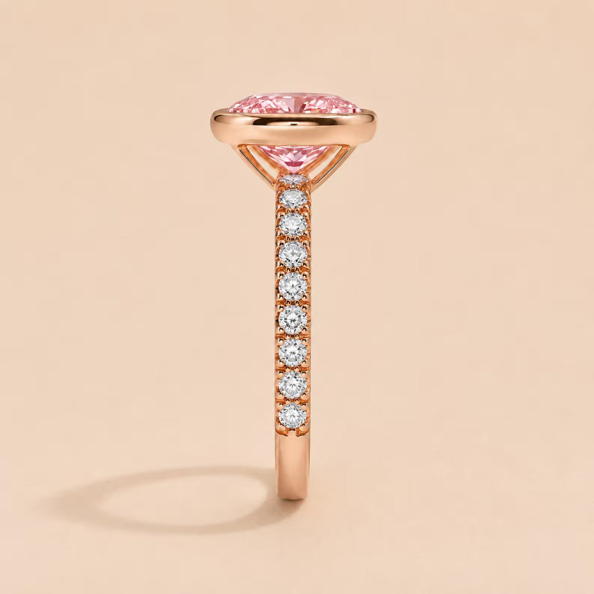 Vertical side view of 2 Carat Pink Oval Cut Lab Diamond Bezel Ring showcasing pave diamond band profile