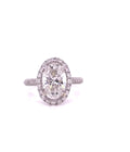 Top-down view of a 4 carat oval lab created diamond ring surrounded by a round diamond halo on a pave-encrusted band.