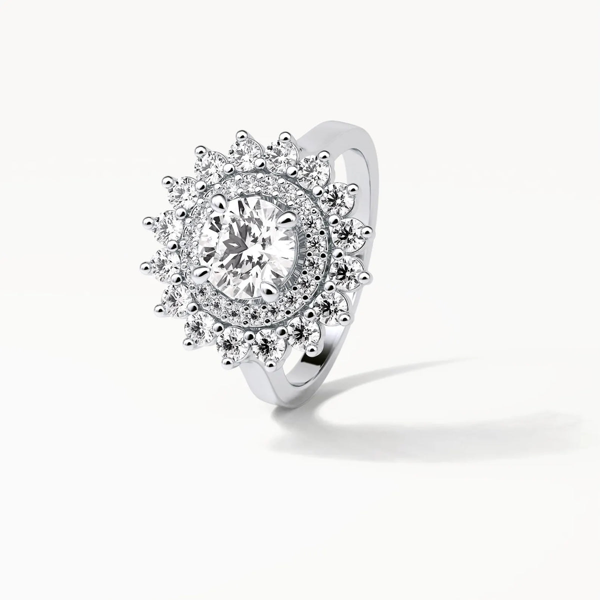 Angled top view displaying the brilliance of a 3 CT round center diamond surrounded by a double starburst halo.
