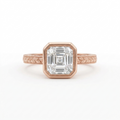 Direct top view of a 3 carat Asscher cut lab grown diamond set in a rose gold bezel frame with vintage leaf engraved band.