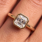 Macro detail shot of bezel-set Asscher cut lab diamond ring on finger