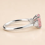 Side profile view of white gold three-stone ring with pear side stones