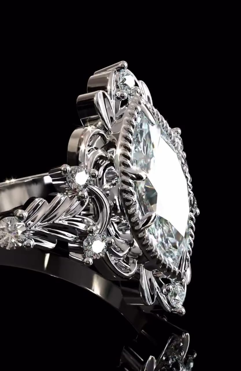 Angled close-up highlighting the leaf-engraved shoulders and accent round diamonds surrounding a marquise diamond.